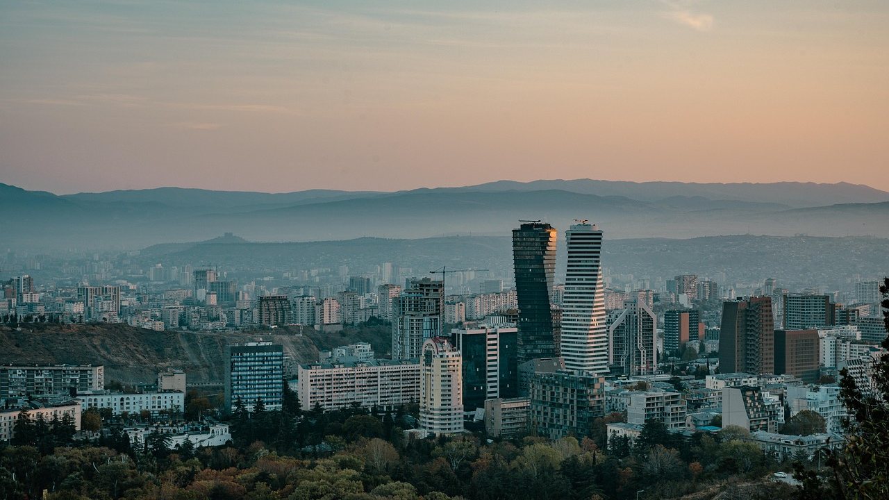 Les hauteurs de Tbilissi au crépuscule, avec les tours Axis au-dessus de la ville